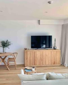 una sala de estar con sofá y TV en un armario en Alby’s - Cotton Tree, en Maroochydore