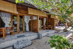 een huis met een patio met stoelen en tafels bij Linas Villas in Nusa Penida