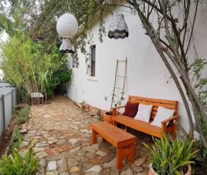 a patio with a wooden bench and a tree at The Secret Figtree Cottage in Clare