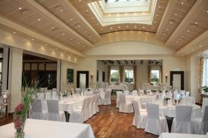 a banquet hall with white tables and chairs at Hotel & Apartments Leugermann in Ibbenbüren