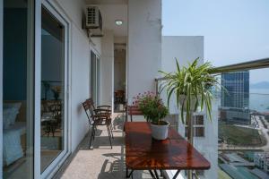 un balcón con una mesa de madera y macetas. en Penhouse 4 ngủ View biển rộng 160m2 en Ha Long