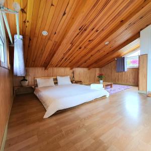 - une chambre avec un grand lit au plafond en bois dans l'établissement KiMi HomeStay, à Da Thien