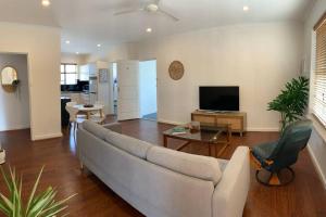 a living room with a couch and a television at Yarrumla Beach Lodge in Somerton Park