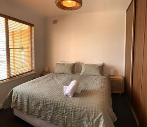 Un dormitorio con una cama con una almohada blanca. en Yarrumla Beach Lodge, en Somerton Park