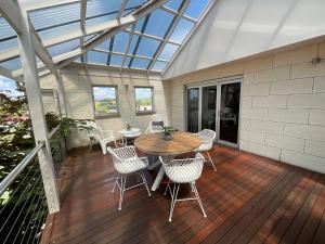 a conservatory with a table and chairs on a deck at Frewville 7A Apartment in Mount Gambier