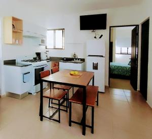 een keuken met een tafel en stoelen en een kamer bij Casa en privada con alberca, Excelente para vacaciones y descanso in Playa del Carmen