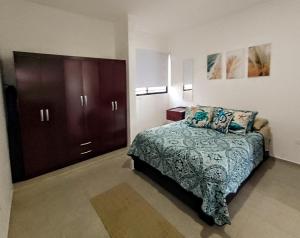 a bedroom with a bed and a dresser in it at Casa en privada con alberca, Excelente para vacaciones y descanso in Playa del Carmen