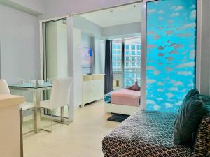 een kamer met een bed en een slaapkamer met een aquarium bij Summer Vibe2 - Beach View in Manilla