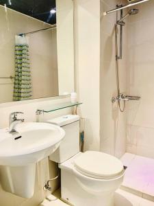 een witte badkamer met een toilet en een wastafel bij Summer Vibe2 - Beach View in Manilla