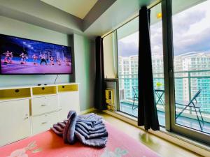 een woonkamer met een groot raam en een televisie bij Summer Vibe2 - Beach View in Manilla