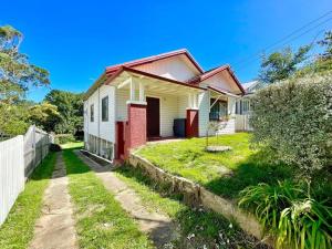een wit en rood huis met een tuin bij Jasmine Cottage in Katoomba