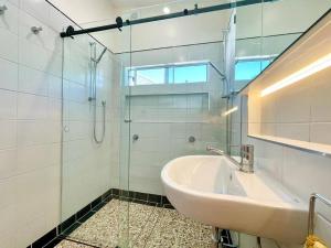 ein Badezimmer mit Waschbecken und Glasdusche in der Unterkunft Jasmine Cottage in Katoomba + 24 Fotos