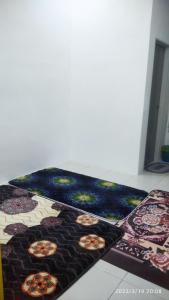een tapijt met gezichten op de vloer bij Rumah Lunas in Lunas