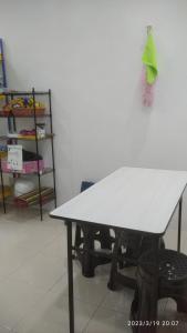 a white table in a room with a shelf at Rumah Lunas in Lunas
