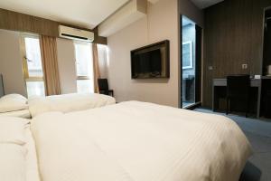 Habitación de hotel con cama y TV en Welove meworld Inn, en Taipéi