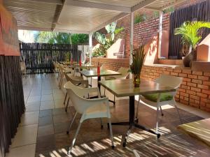 a restaurant with tables and chairs on a patio at St Lucia Lodge in St Lucia