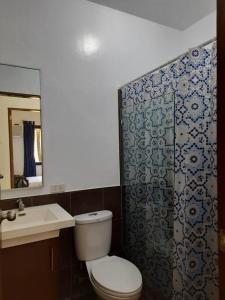 W łazience znajduje się toaleta, prysznic i umywalka. w obiekcie Sunset Beach House Siargao w mieście General Luna