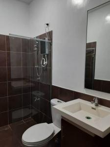 La salle de bains est pourvue de toilettes, d'une douche et d'un lavabo. dans l'établissement Sunset Beach House Siargao, à General Luna