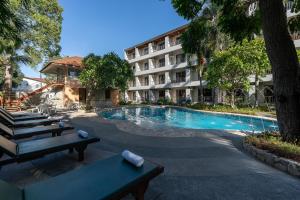 a hotel with a swimming pool in front of a building at Bella Villa Pattaya 3rd Road in Pattaya