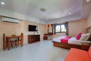 a bedroom with a bed and a desk and a television at Rak Samui Residence in Bophut 