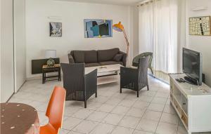 een woonkamer met een bank en stoelen en een televisie bij Stunning Home In La Faute Sur Mer With Kitchen in La Faute-sur-Mer