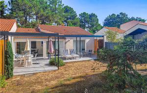 een huis met een patio met stoelen en parasols bij Stunning Home In La Faute Sur Mer With Kitchen in La Faute-sur-Mer