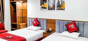 2 Betten in einem Zimmer mit roten Kissen darauf in der Unterkunft Rosy Hotel Dương Nội in Hà Ðông