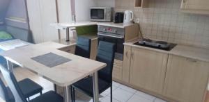 a small kitchen with a stove and a table at Levendula in Békéscsaba