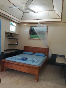 een bed in een kamer met een plafond bij Bunaken Sunrise Beach in Manado