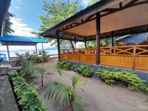 een paviljoen met planten voor een strand bij Bunaken Sunrise Beach in Manado
