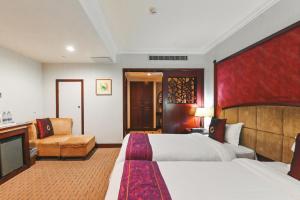 a hotel room with two beds and a couch at Royal Plaza Hotel in Guangzhou