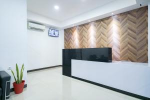a reception desk in a room with a wall at Urbanview Hotel Max Living Cengkareng in Jakarta
