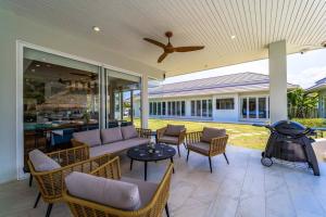 un patio con divano, sedie e tavolo di Luxury 7 Bedroom Pool Villa! (WL67) a Hua Hin