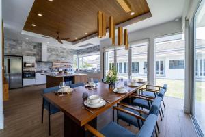una sala da pranzo con un grande tavolo in legno e sedie blu di Luxury 7 Bedroom Pool Villa! (WL67) a Hua Hin