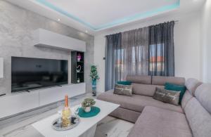 Una sala de estar con un sofá y un televisor. en Apartman Luxury Lure, en Krk