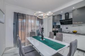 Una cocina y un comedor con una mesa y sillas blancas. en Apartman Luxury Lure, en Krk