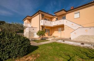 una casa grande con césped delante en Apartman Luxury Lure, en Krk