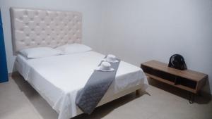 1 dormitorio con cama blanca y mesa en Tu hogar en Cali Apto centrico cómodo y privado, en Cali
