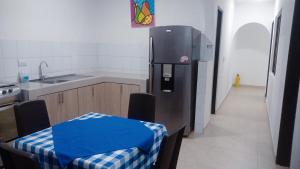 eine Küche mit einem Kühlschrank und einem Tisch darin in der Unterkunft Tu hogar en Cali Apto centrico cómodo y privado in Cali
