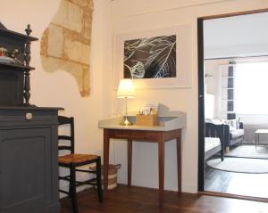 een kamer met een tafel met een lamp en een woonkamer bij Grange Bleuet in Aubeterre-sur-Dronne