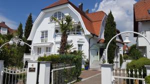une maison blanche avec une clôture blanche dans l'établissement Boutique Hotel Villa am See, à Hagnau am Bodensee
