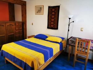 a bedroom with a bed and a table and a chair at Casa Donaji in Oaxaca City
