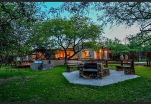 a house with a picnic table in the grass at Turaco Lodge - No Loadshedding in Marloth Park