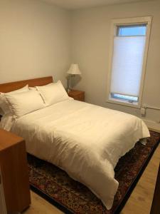 1 dormitorio con cama blanca y ventana en Modern condo steps from the ocean en Anchorage