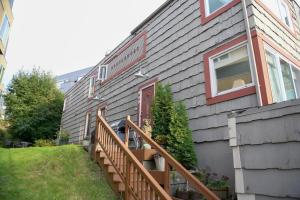 una casa con una escalera de madera junto a un edificio en Modern condo steps from the ocean en Anchorage