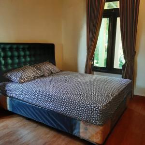 เตียงในห้องที่ Singgamira Homestay Jogja