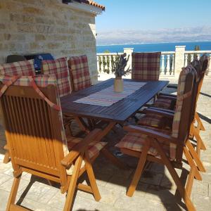 una mesa de madera y sillas con vistas al océano en Apartmani Afrodita en Sutivan