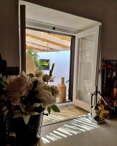 a vase of flowers on a counter in front of a window at Casa BOHO in Alaminos