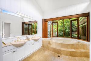HolgateMoroccan Acreage -Heated Pool w Slide -Sleeps 22的一间带两个盥洗盆和浴缸的浴室以及窗户。