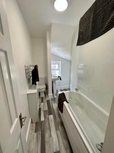 a white bathroom with a tub and a toilet at Chic & Cosy Studio Apartment in Southampton